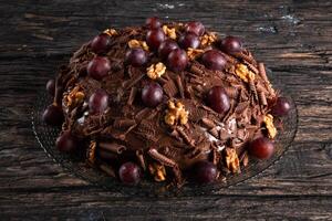 gâteau avec Chocolat glaçage et les raisins sur une rustique Contexte photo