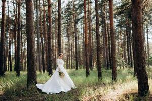 la mariée marchant dans une forêt de pins photo