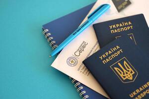 Kyiv, Ukraine - novembre 27, 2023 passeport un service logo avec international ukrainien passeport et stylo photo