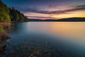 une Lac entouré par des arbres à le coucher du soleil photo