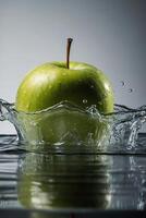 un Pomme est éclabousser dans le l'eau photo