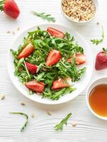 Frais fraise Roquette salade avec pin des noisettes servi sur une brillant journée photo