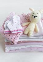 empiler de bébé vêtements, chaussettes et tricoté jouet photo