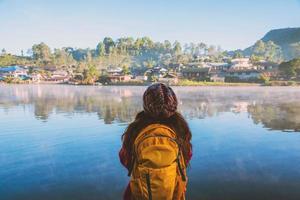 la femme debout près du lac, elle souriait, appréciait et appréciait la beauté naturelle de la brume. photo