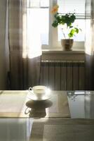 tasse de chaud fumant café sur une ensoleillé Matin sur le cuisine table photo