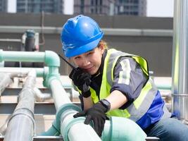 femelle femme Dame la personne gens Humain bleu casque casque réparation tuyau outil maison vérifier en haut clé équipement évier travail emploi l'eau bricoleur plombier cuisine Accueil maison construction robinet salle de bains industrie photo