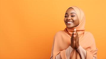 africain femme portant écharpe est prier et souriant sur Jaune Contexte photo