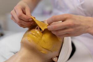 une fille à une cosmétologue Est-ce que cosmétique procédures. alginate masque photo