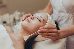 une fille à une cosmétologue Est-ce que cosmétique procédures. peau nettoyage photo