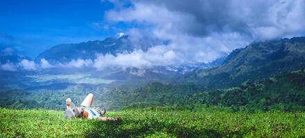 asiatique femme Voyage se détendre dans le vacances. sommeil se détendre sur le pelouse sur le Montagne. dans Thaïlande photo