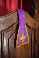 étole violette d'un prêtre reposant sur un confessionnal