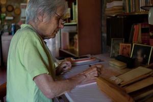 Une dame des années 70 écrit ses mémoires dans la paix et la tranquillité de sa maison. photo