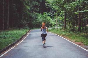 les femmes font de l'exercice dans la rue. parc naturel. fille qui lève les jambes pour faire de l'exercice. exercice, course, fille qui fait du jogging. photo