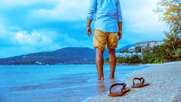 homme asiatique voyage nature. voyage se détendre. Marcher sur la plage. en été photo