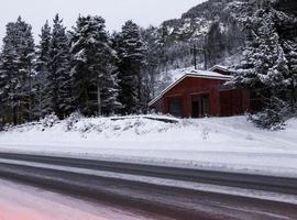 conduire la nuit à travers les montagnes, les villages, les forêts en norvège. photo