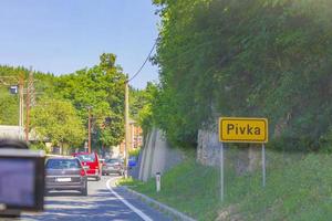 panneau jaune de nom de lieu et route vers postojna pivka slovénie. photo