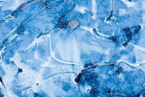 texture de l'eau gelée bleue avec motif sur la rivière dans la forêt d'hiver à l'extérieur photo