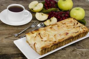 Tarte aux pommes d'automne avec des baies de viorne sur fond de bois photo