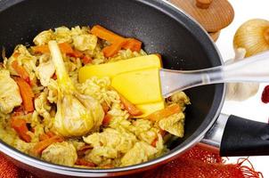 pilaf. riz avec de la viande et des légumes dans une poêle à frire sur fond blanc. studio photo