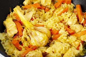 pilaf. riz avec de la viande et des légumes dans une poêle à frire sur fond blanc. studio photo