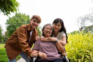 asiatique prudent soignant ou infirmière prise se soucier de le patient dans une fauteuil roulant. concept de une content retraite avec se soucier de une soignant et des économies et Sénior santé assurance, une content famille photo