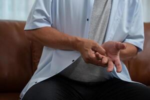 personnes âgées asiatique Masculin les patients souffrir de engourdissant douleur dans mains de rhumatoïde arthrite. Sénior Hommes massage le sien main avec poignet douleur. concept de mixte douleur, rhumatoïde arthrite, et main problèmes. photo