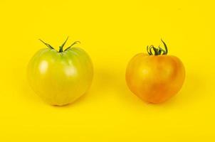 mélange de tomates mûres colorées sur fond jaune vif. studio photo