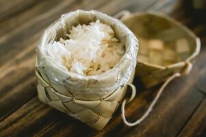 blanc gluant riz dans une panier tissé avec paume feuilles. photo