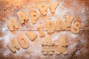 fond avec joyeuses fêtes écrit avec des lettres de pâte à biscuits et du sucre en poudre photo