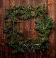 Cadre de branche de sapin de Noël sur un fond en bois foncé photo