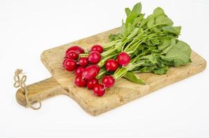 bouquet de radis frais sur une planche à découper en bois de cuisine. studio photo