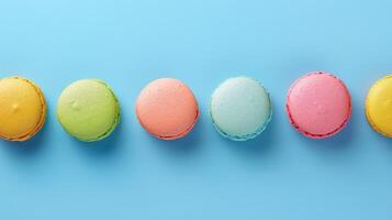 une rangée de coloré macarons sur une bleu Contexte photo