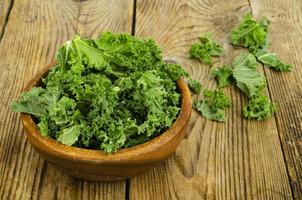 feuilles de sabellica vertes fraîches sur fond en bois, aliments biologiques sains. photo