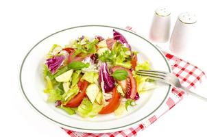 assiette avec laitue, tomates, huile d'olive. menu végétarien. photo