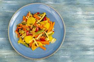 mélange de légumes bouillis dans des aliments diététiques, fond bleu. photo