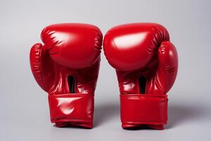 rouge boxe gants mis sur une plaine gris surface, prêt pour une formation session ou une lutte. photo