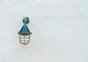 vieille lampe suspendue sur mur blanc photo