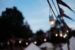 équipé et électrique avec lumière ampoules est brillant et pendaison dans crépuscule de le coucher du soleil avant nuit photo