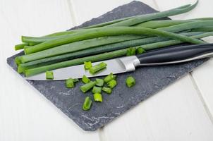 couper les tiges d'oignons verts, un ingrédient en cuisine photo