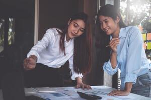 diverse équipe de Jeune affaires gens habillé dans formel porter coopérer sur développement commun conception projet et appel par portable ordinateur. photo