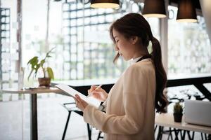 femme d'affaires propriétaire faire les publicités. ouvert maintenant sur social médias. café ou restaurant et affaires rouvrir après covid-19 quarantaine est sur. photo