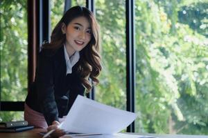 asiatique femme d'affaires en cours d'analyse le affaires rapport dans le bureau. photo