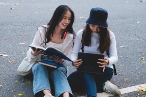 deux élèves sont séance dans Université pendant en train de lire une livre et communication. étude, éducation, université, collège, diplômé concept. photo