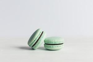 deux français macarons sur une blanc en bois tableau. menthe macarons. blanc Contexte. photo