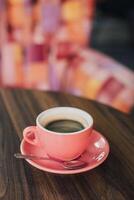 rose tasse de noir café sur une table dans une café. photo