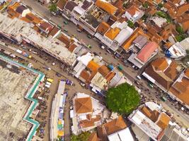 aérien vue de principale rue de Ouest Java province, Indonésie. le principale route dans le milieu de Résidentiel domaines. motos, voitures et électrique Véhicules circulation sur le principale route. coup de une drone en volant photo