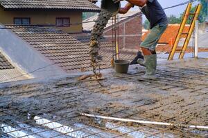 industriel la photographie. construction travail activités. une ouvrier est verser ciment dans câble engrener pendant le sol verser processus. bandung - Indonésie, Asie photo