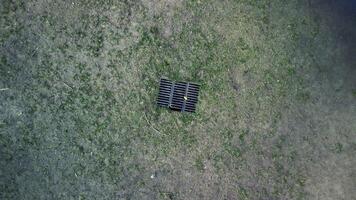 aérien drone vue sur sec herbe et le fer métal drainer égout la grille dans Terre. photo