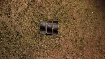 Haut aérien vue sur sec Jaune herbe, sol et drainer égout la grille dans Terre. photo