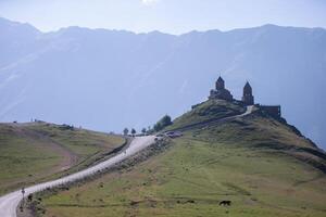 proche vue de saint trinité église dans Kazbegi Montagne intervalle près stepantsminda vue Caucase montagnes dans le Contexte photo